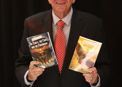 Robert B. Sloan with the first two books in his young adult fantasy series