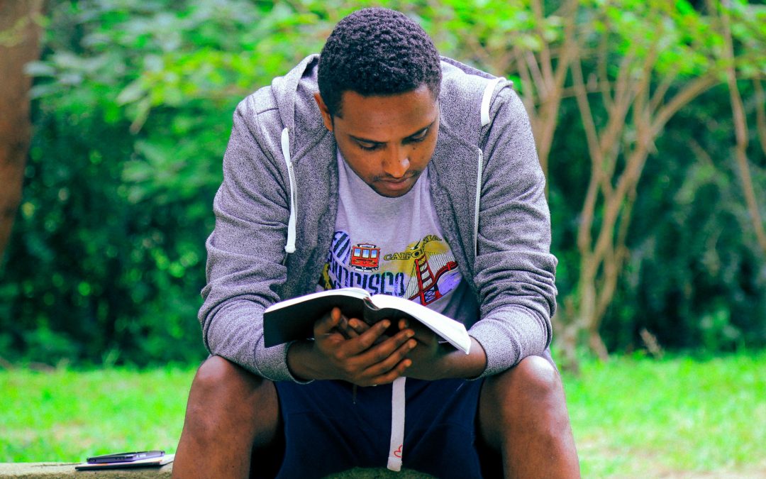 Christian-scriptures-man in San Francisco-shirt-reading-book-outside-bench-wisdom-college-students-Why You Should Read The Bible-rbs-blog-image_gift-habeshaw-699056-unsplash